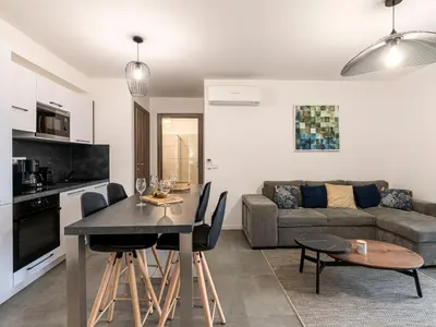 a kitchen and living room with a table and a couch at Apartment St Joseph-2 by Interhome in Porto-Vecchio