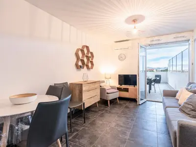 a living room with a couch and a table and a tv at Apartment La Boétie A by Interhome in Porto-Vecchio