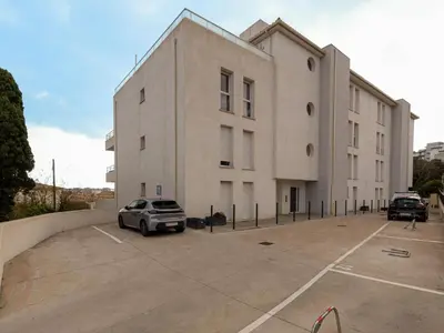 a building with a car parked in a parking lot at Apartment La Boétie A by Interhome in Porto-Vecchio