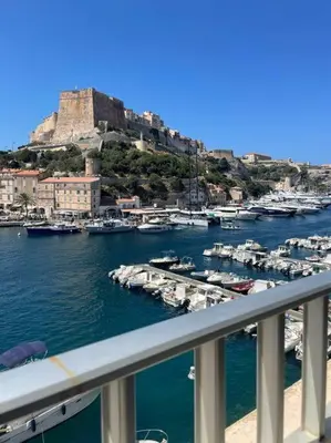 a view of a marina with boats in the water at Sur le port face à la citadelle in Bonifacio