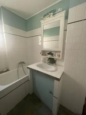 a bathroom with a sink and a mirror and a tub at Sur le port face à la citadelle in Bonifacio