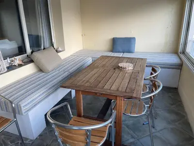 a small table and chairs in a room with a bed at Sur le port face à la citadelle in Bonifacio