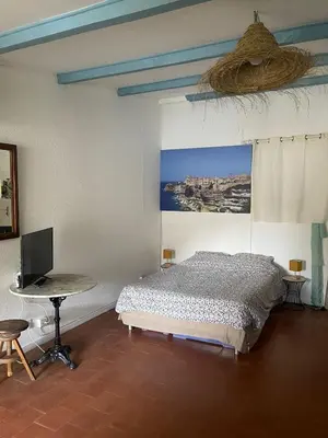 a bedroom with a bed and a desk with a computer at Sur le port face à la citadelle in Bonifacio