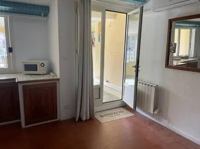 a kitchen with a sliding glass door to a balcony at Sur le port face à la citadelle in Bonifacio