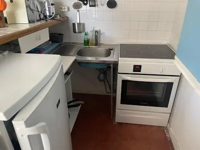 a small kitchen with a sink and a stove at Sur le port face à la citadelle in Bonifacio