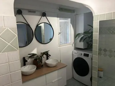 a bathroom with two sinks and two mirrors on the wall at Villa l'Albizia accès privé rivière in Porto-Vecchio