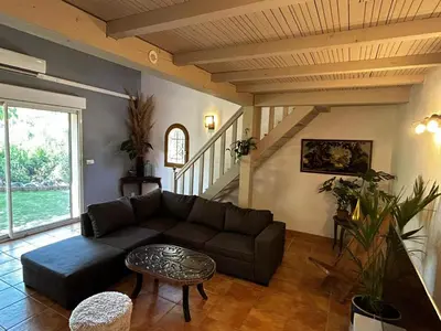a living room with a couch and a table at Villa l'Albizia accès privé rivière in Porto-Vecchio