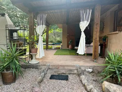 a pavilion with white curtains and plants in it at Villa l'Albizia accès privé rivière in Porto-Vecchio