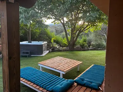 a picnic table and a bench in a yard at Villa l'Albizia accès privé rivière in Porto-Vecchio