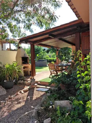 a wooden pergola with a table and a grill at Villa l'Albizia accès privé rivière in Porto-Vecchio