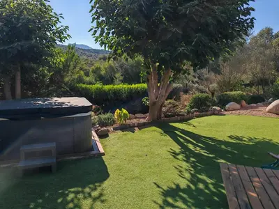 a garden with a bench and a tree at Villa l'Albizia accès privé rivière in Porto-Vecchio