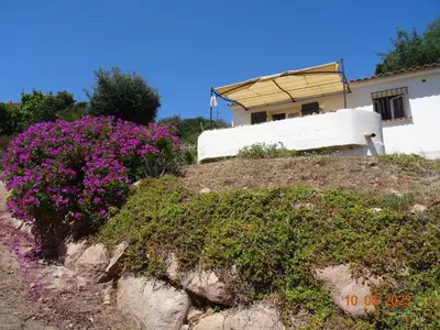 a house on a hill with purple flowers at Villa indépendante 2/5 personnes - Palombaggia Vue mer magnifique Porto Vecchio in Porto-Vecchio