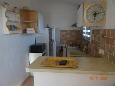 a kitchen with a cutting board on a counter with a clock at Villa indépendante 2/5 personnes - Palombaggia Vue mer magnifique Porto Vecchio in Porto-Vecchio