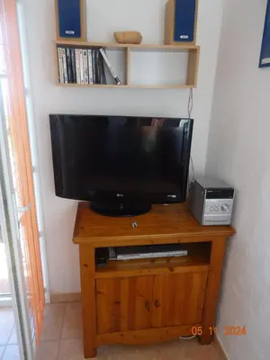a television on a wooden stand in a room at Villa indépendante 2/5 personnes - Palombaggia Vue mer magnifique Porto Vecchio in Porto-Vecchio
