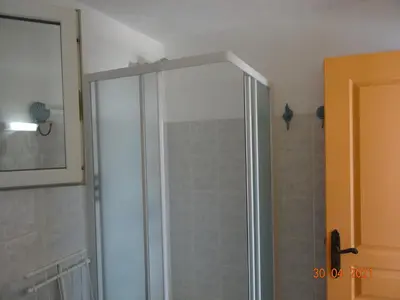 a shower with a glass door in a bathroom at Villa indépendante 2/5 personnes - Palombaggia Vue mer magnifique Porto Vecchio in Porto-Vecchio