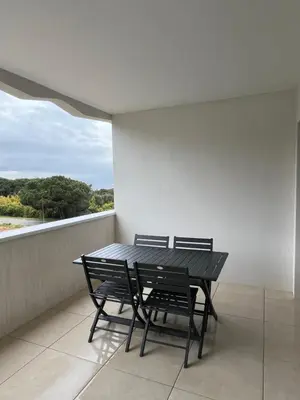 a black table and two chairs on a balcony at Loc A Machja Fiurita - Vue mer in Pietrosella