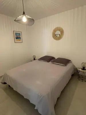 a bedroom with a large white bed with two pillows at Loc A Machja Fiurita - Vue mer in Pietrosella