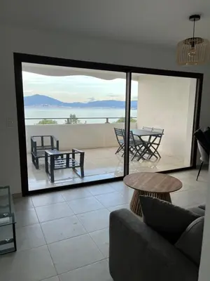 a living room with a couch and a view of the ocean at Loc A Machja Fiurita - Vue mer in Pietrosella