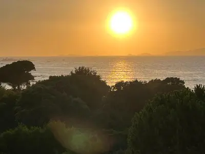 a sunset over the ocean with trees in the foreground at Loc A Machja Fiurita - Vue mer in Pietrosella