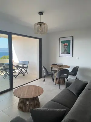 a living room with a couch and tables at Loc A Machja Fiurita - Vue mer in Pietrosella