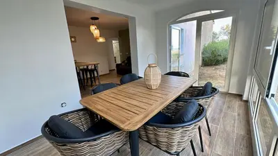 a wooden table with blue chairs and a dining room at CASA MARE in Ghisonaccia