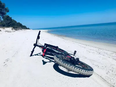 a bike laying on a beach next to the ocean at CASA MARE in Ghisonaccia