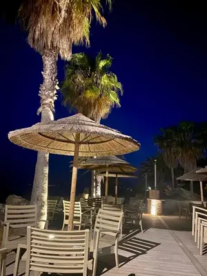 a group of chairs and umbrellas on the beach at night at CASA MARE in Ghisonaccia