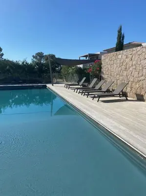 a row of chairs sitting next to a swimming pool at Villa U Sanda in Lecci