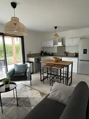 a living room with a table and a kitchen at Villa U Sanda in Lecci