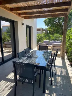 a dining table and chairs on a patio at Villa U Sanda in Lecci