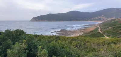 a view of a beach with mountains and the ocean at Studio à la campagne in Villanova