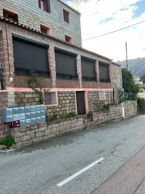 a brick building with windows on the side of a street at Residence Appartement le Porto in Porto Ota