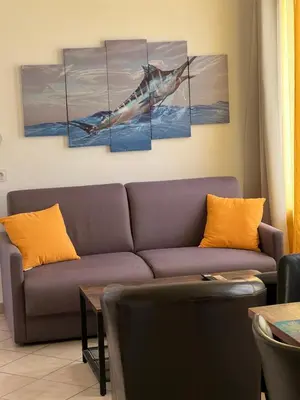 a living room with a whale painting on the wall at Residence Appartement le Porto in Porto Ota