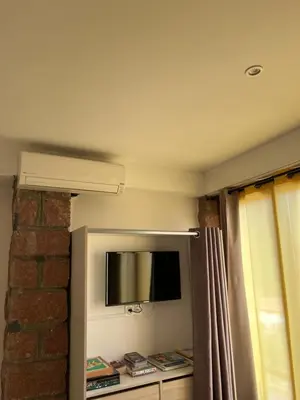 a room with a tv on a wall with a curtain at Residence Appartement le Porto in Porto Ota