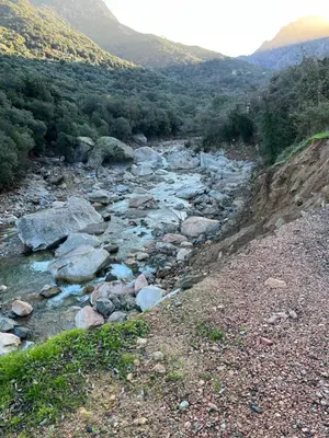 a river with rocks and mountains in the background at Residence Appartement le Porto in Porto Ota