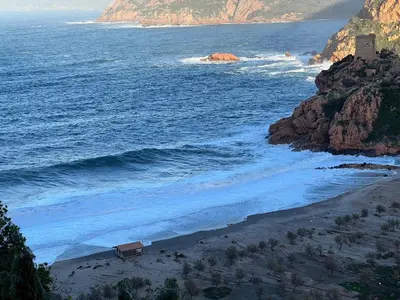 a view of a beach with a house on the shore at Residence Appartement le Porto in Porto Ota