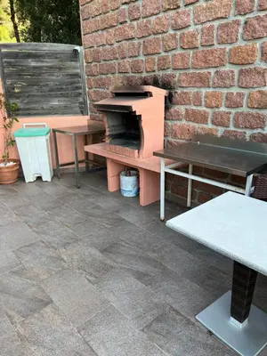 a patio with benches and a brick wall at Residence Appartement le Porto in Porto Ota