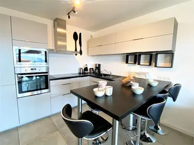 a kitchen with a black table and black chairs at Les terrasses de l'Isolella in Porticcio