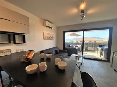 a living room with a black table and a couch at Les terrasses de l'Isolella in Porticcio