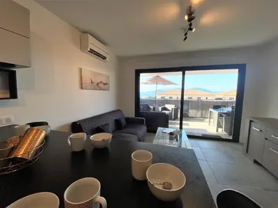 a kitchen and living room with a view of a patio at Les terrasses de l'Isolella in Porticcio