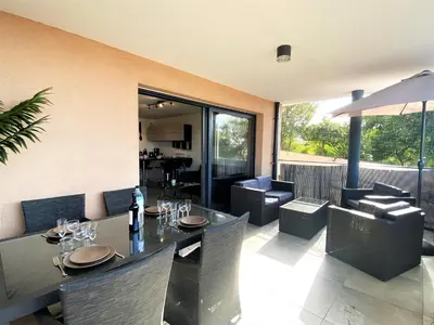 a dining room with a table and chairs at Les terrasses de l'Isolella in Porticcio