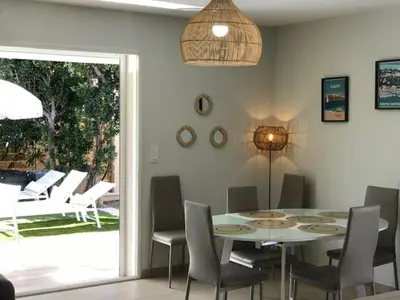 a dining room with a white table and chairs at villa Pinarello in Pinarellu
