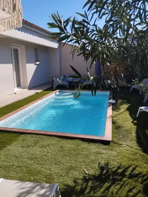 a swimming pool in a yard next to a house at villa Pinarello in Pinarellu