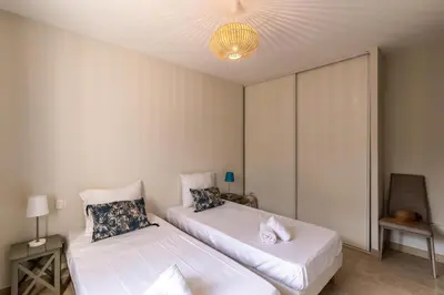 a bedroom with two beds and a chandelier at villa Pinarello in Pinarellu