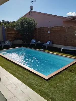 a swimming pool in a yard with a fence at villa Pinarello in Pinarellu