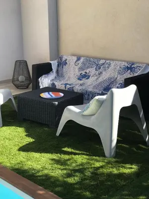 a living room with a couch and a green rug at villa Pinarello in Pinarellu