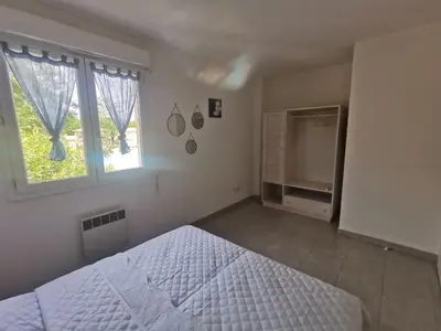 a white bedroom with a bed and a window at Villa Melody duplex climatisée piscine in Santa-Maria-Poggio
