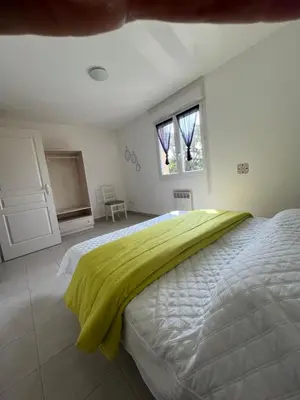 a bedroom with a bed with a green blanket on it at Villa Melody duplex climatisée piscine in Santa-Maria-Poggio