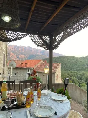 a table with plates of food and drinks on a patio at Appartement au cœur d’un village in Foce