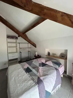 a bedroom with a large bed in a attic at Appartement au cœur d’un village in Foce